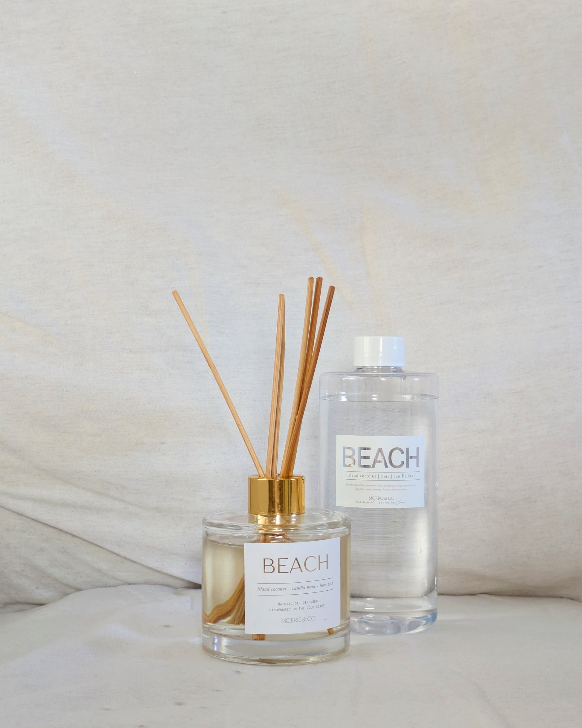 Two natural eco reed diffusers labeled 'Beach' on a neutral background