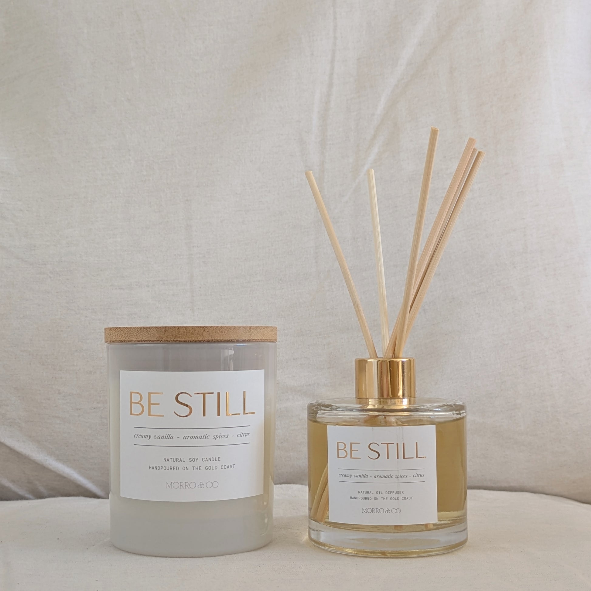 Candle and diffuser set with 'BE STILL' labels on a neutral background