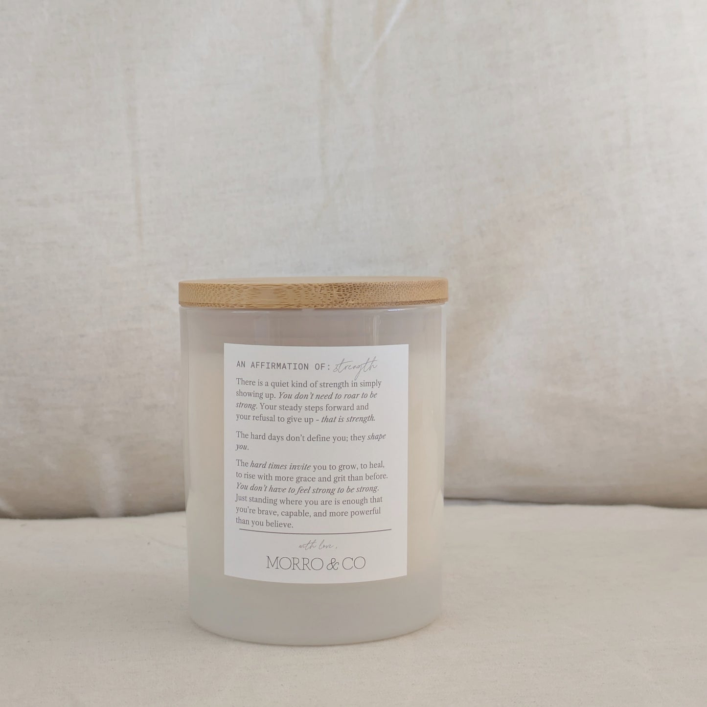 STRONG candle with affirmation label on a beige cushion