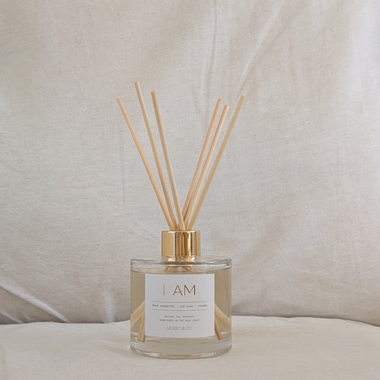 Eco Reed diffuser with wooden sticks in a clear bottle on a neutral background