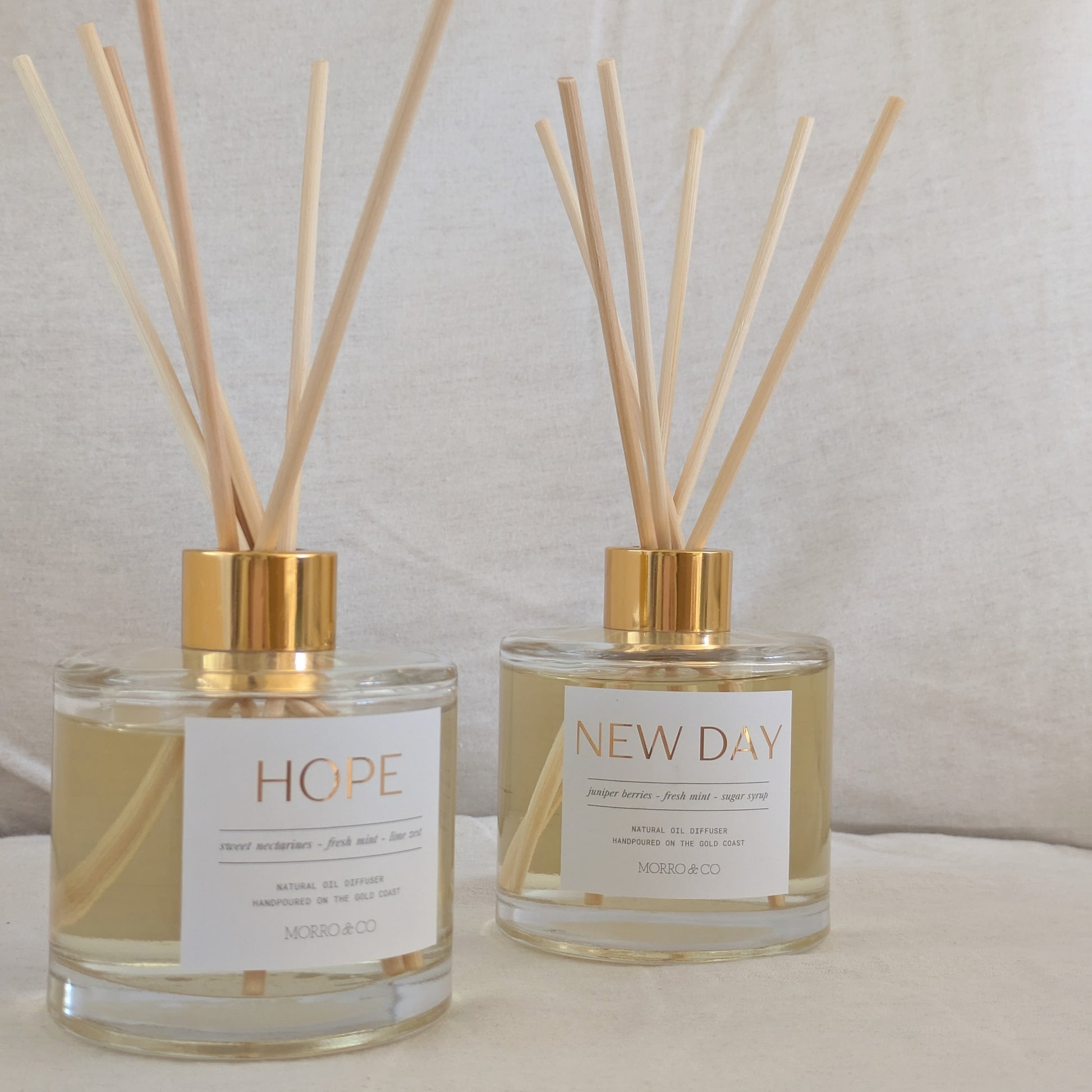 Two eco reed diffusers labeled 'Hope' and 'New Day' on a neutral background