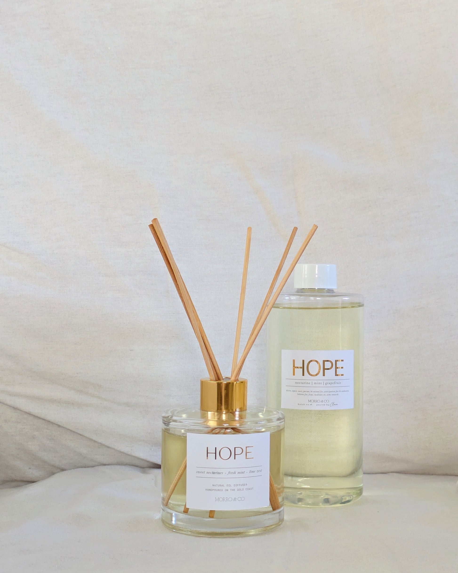 Two 'HOPE' eco reed diffusers on a light background
