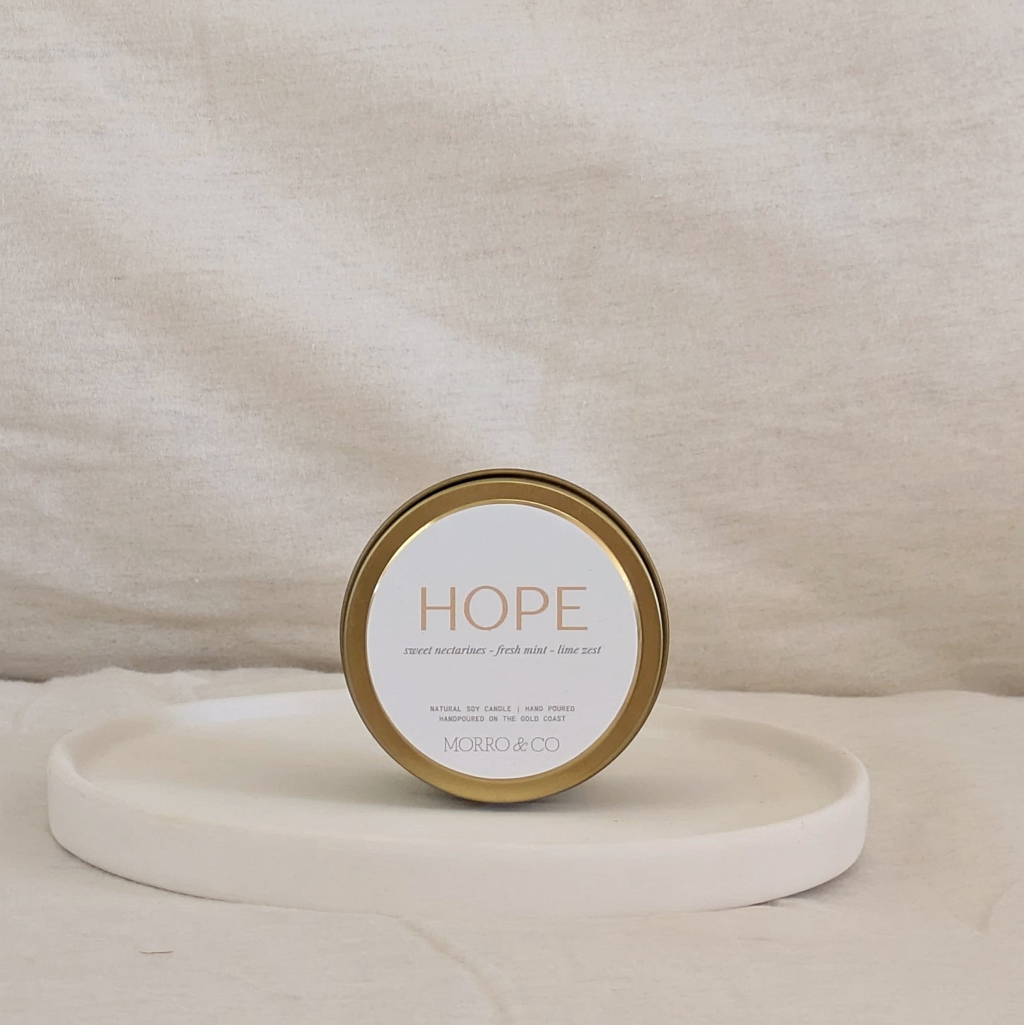 Candle jar labeled 'HOPE' by Morro & Co on a beige background