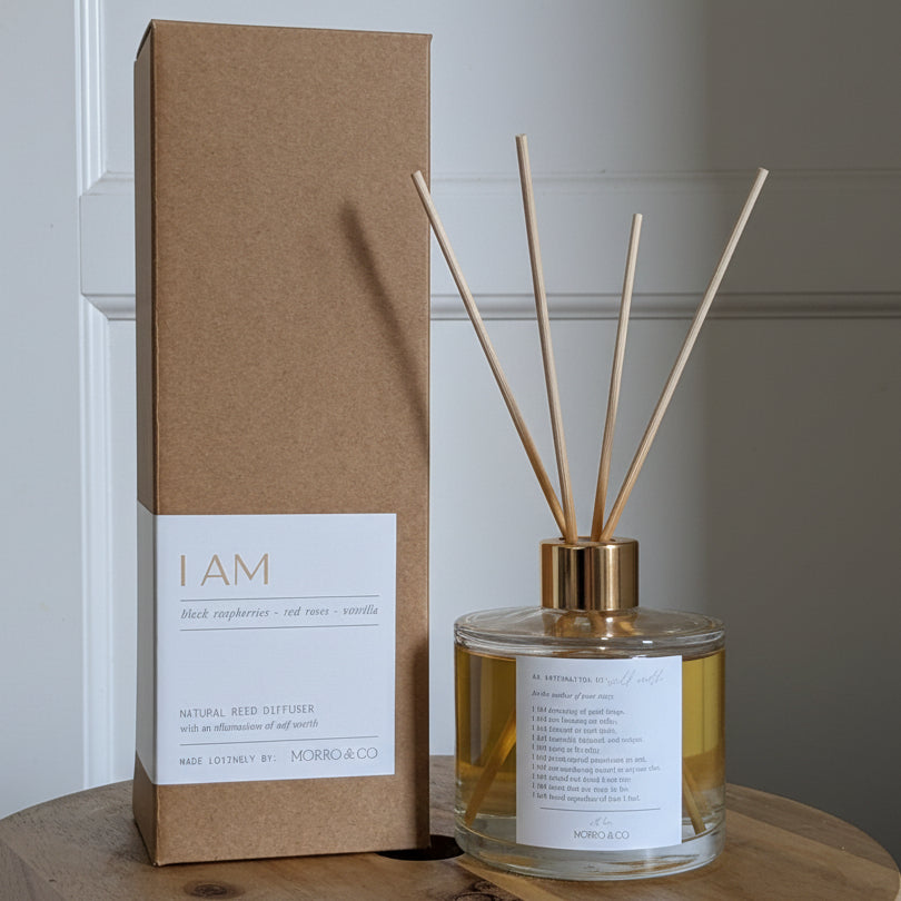 Diffuser and packaging on a wooden surface with a neutral background