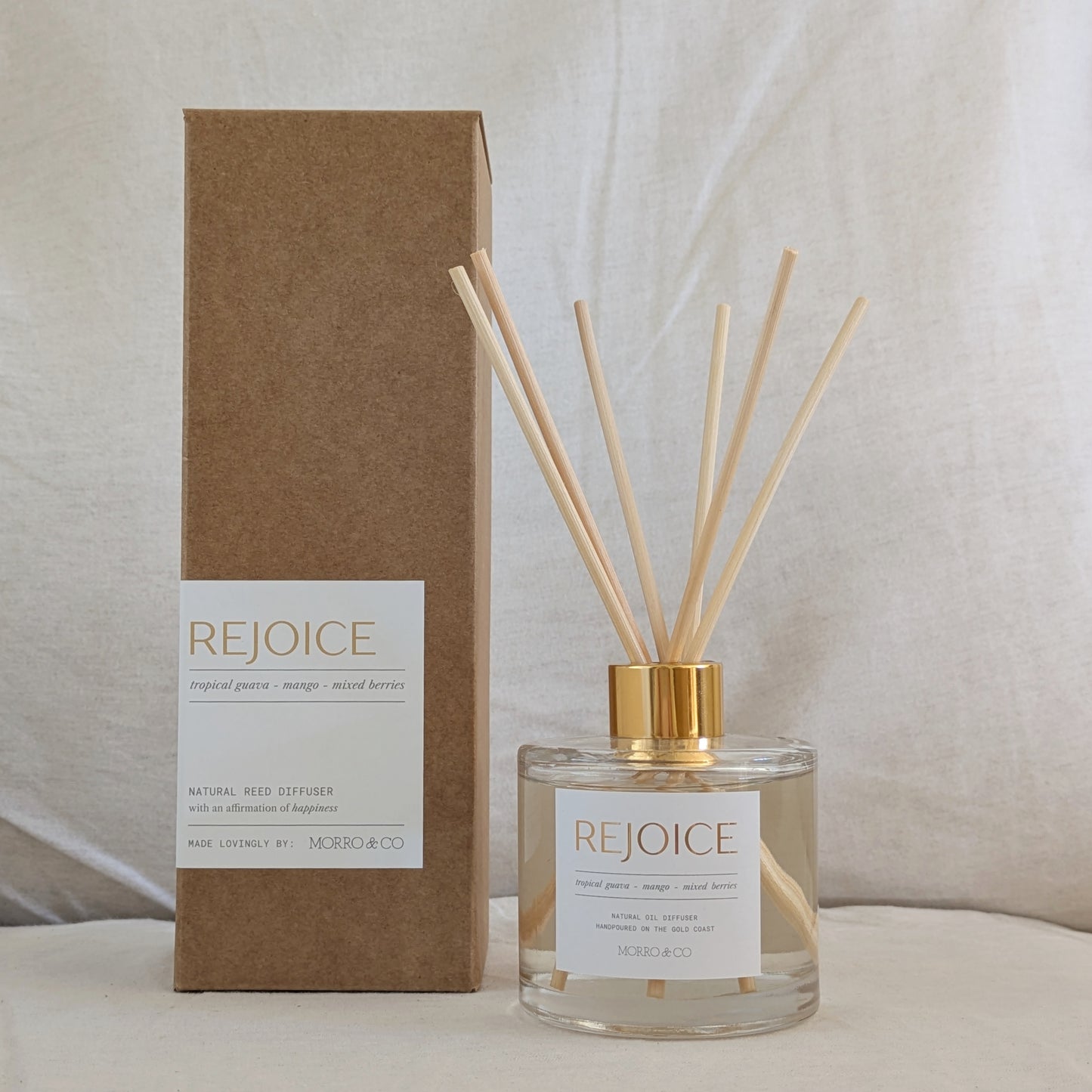 Rejoice eco reed diffuser bottle with reeds and packaging on a neutral background