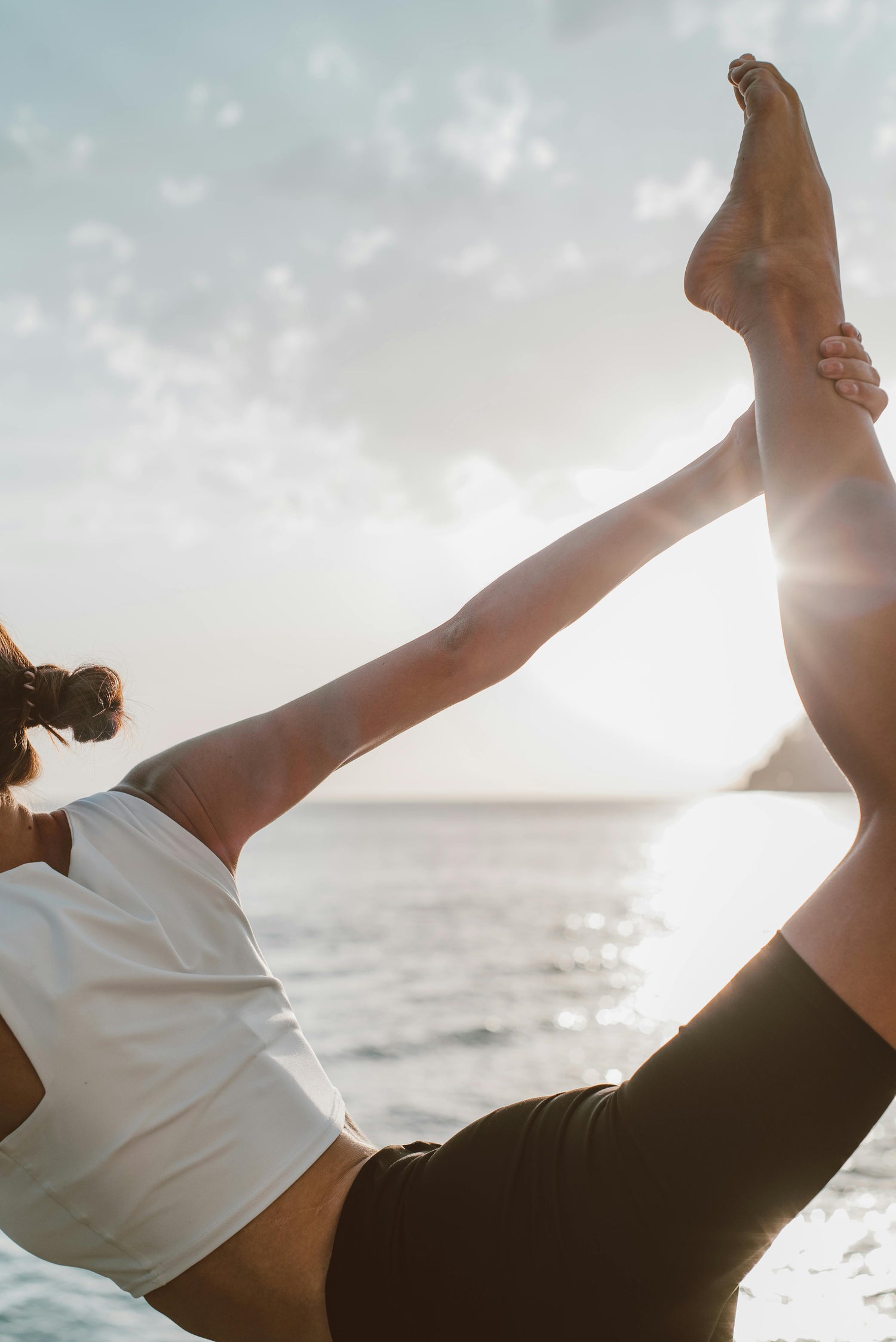 woman stretching one leg by the beach