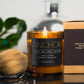 Morro & Co masculine candle with 'Anchor' branding on a reflective surface, with a blurred background