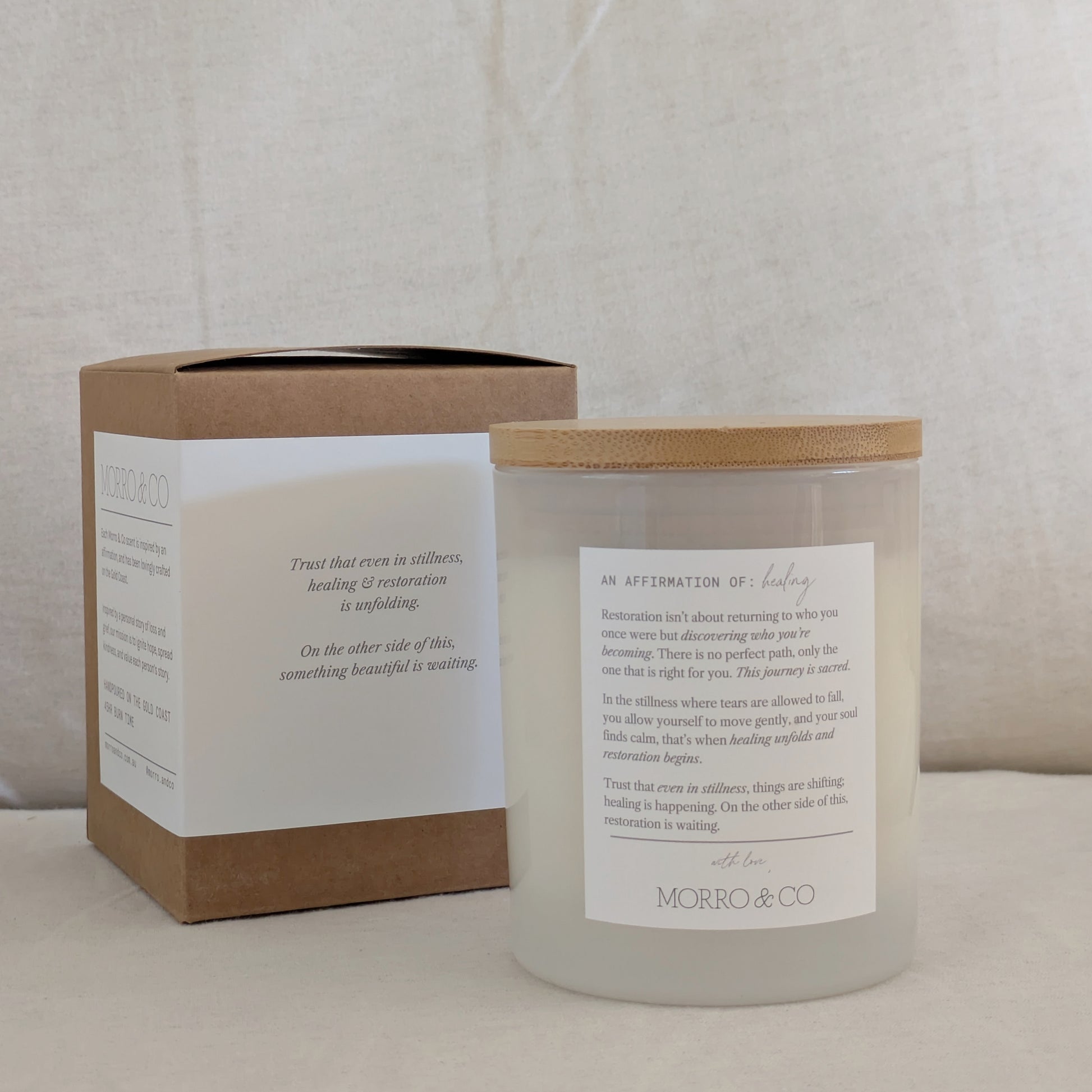 Back of RESTORE candle with affirmation label and packaging with text on a neutral background