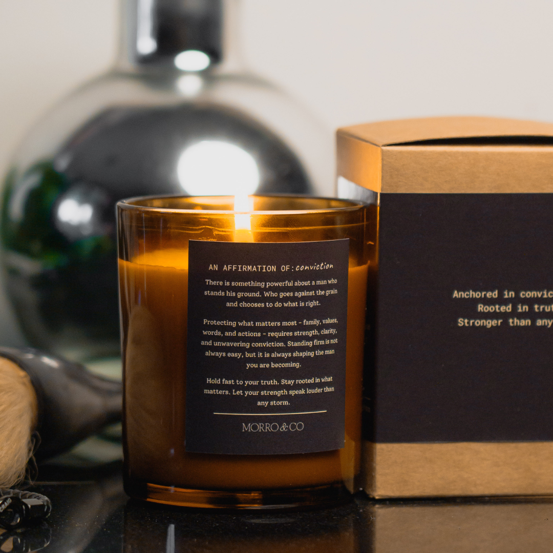 Candle with a label and packaging in the background