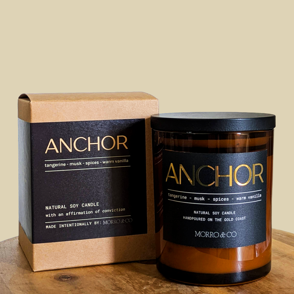 Anchor candle and packaging on a wooden surface with a beige background