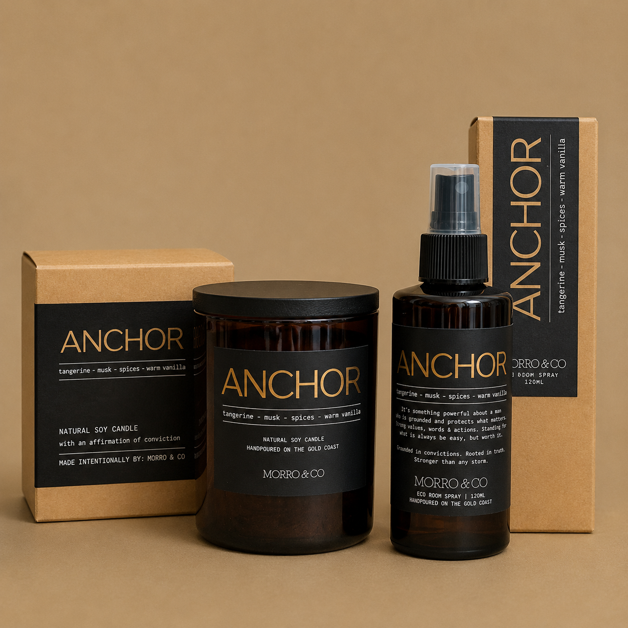 Morro & Co Anchor natural soy candle and matching amber spray bottle with black labels, shown with kraft paper packaging boxes on a warm beige background.