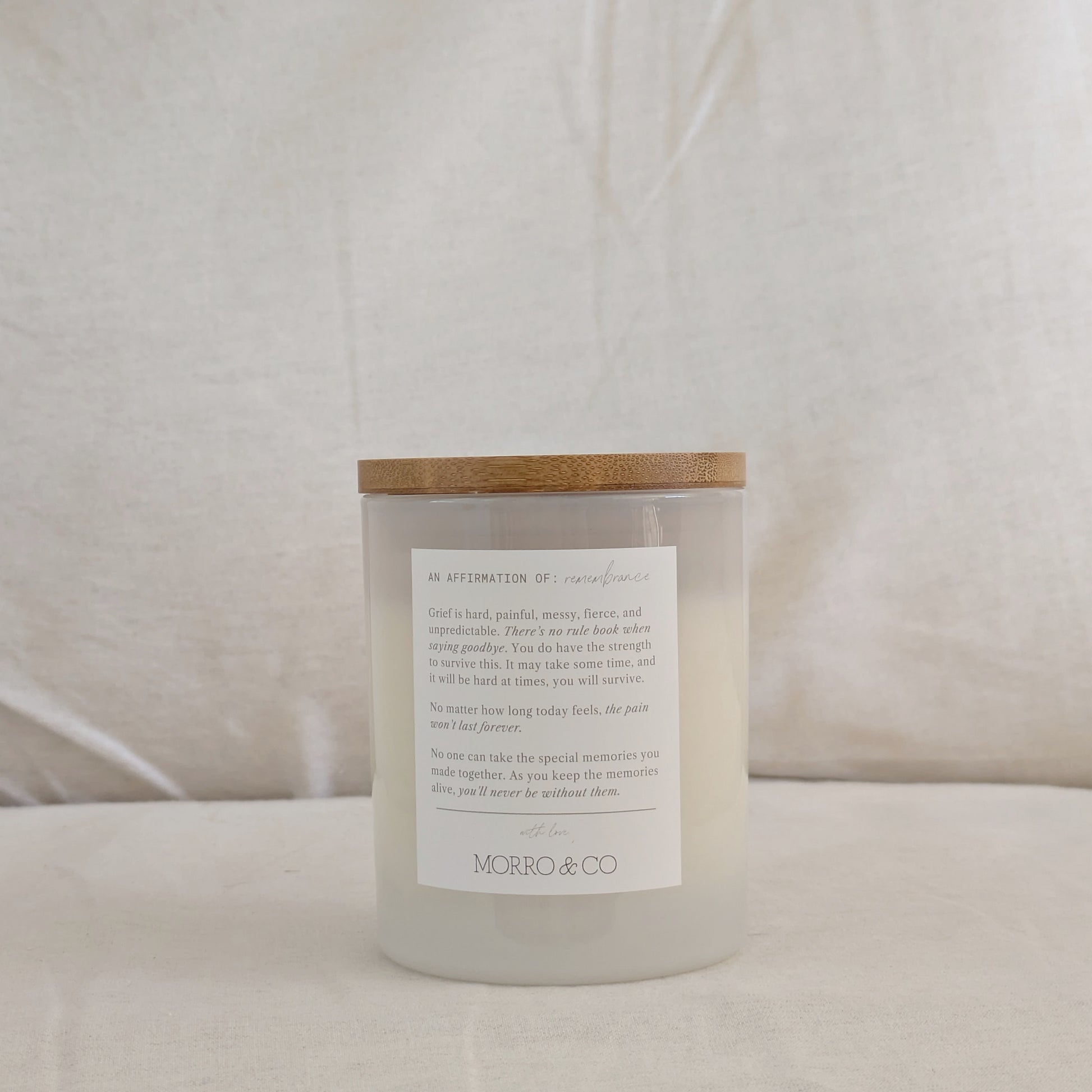 Back of Heaven candle with a wooden lid and affirmation label on a white background