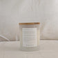 Back of HOPE candle with a wooden lid and affirmation label on a neutral background