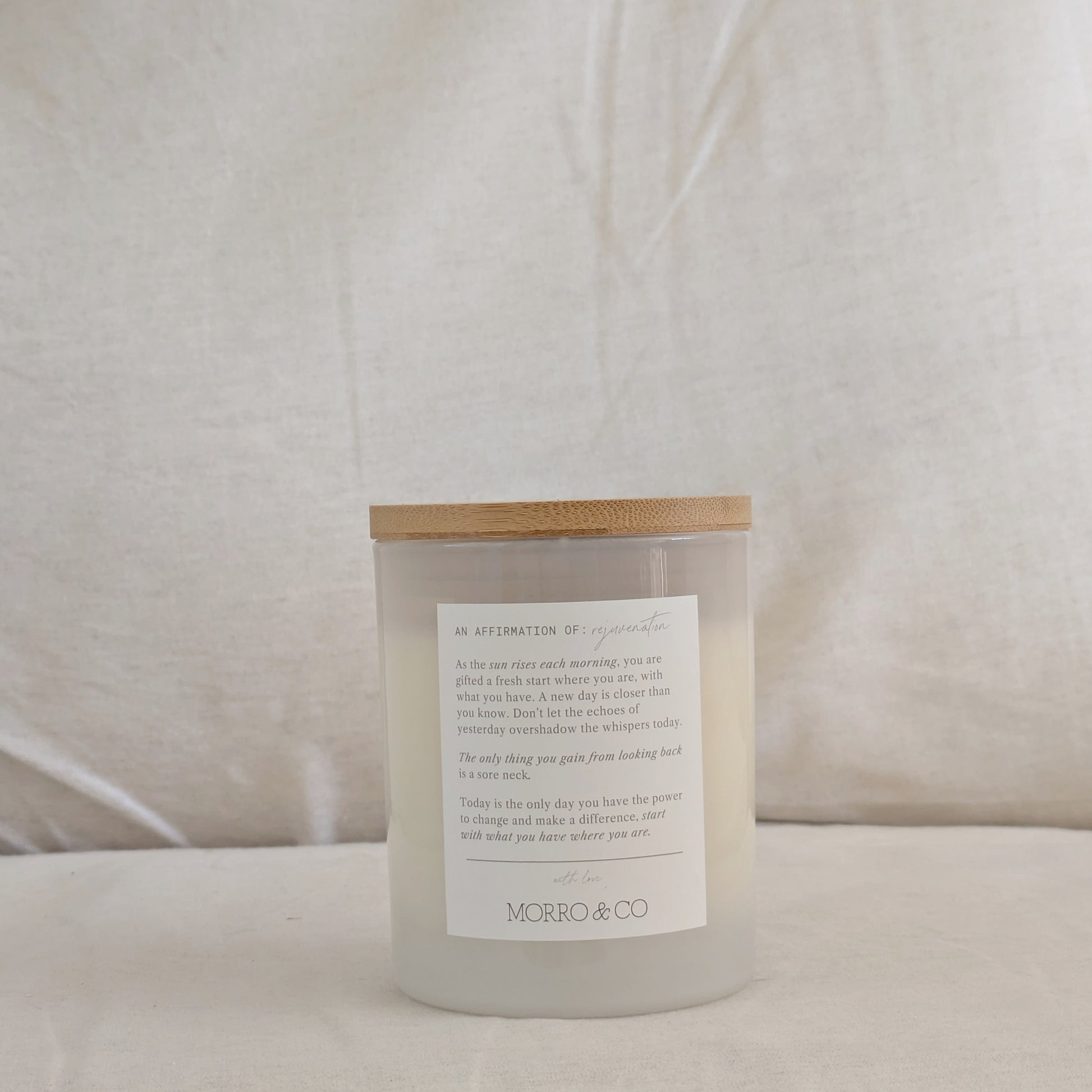 Back of NEW DAY candle with an affirmation label on a white background
