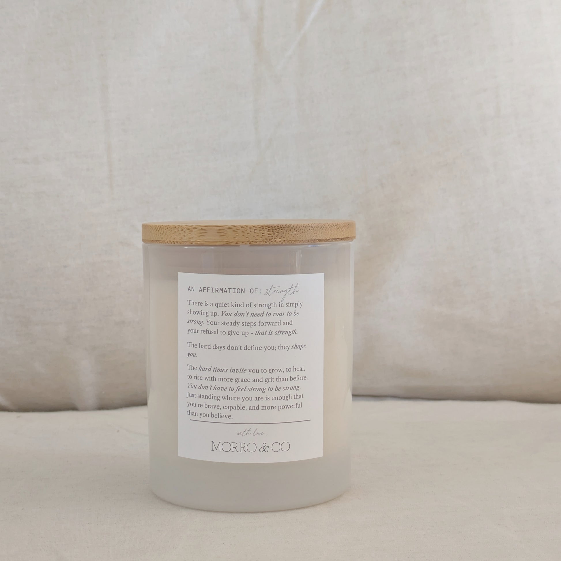 STRONG candle with affirmation label on a beige cushion