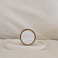 Gold candle travel tin labeled 'Beach' on a beige surface