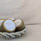 Gold candle travel tins with 'HOPE' and 'STRONG' on a beige surface