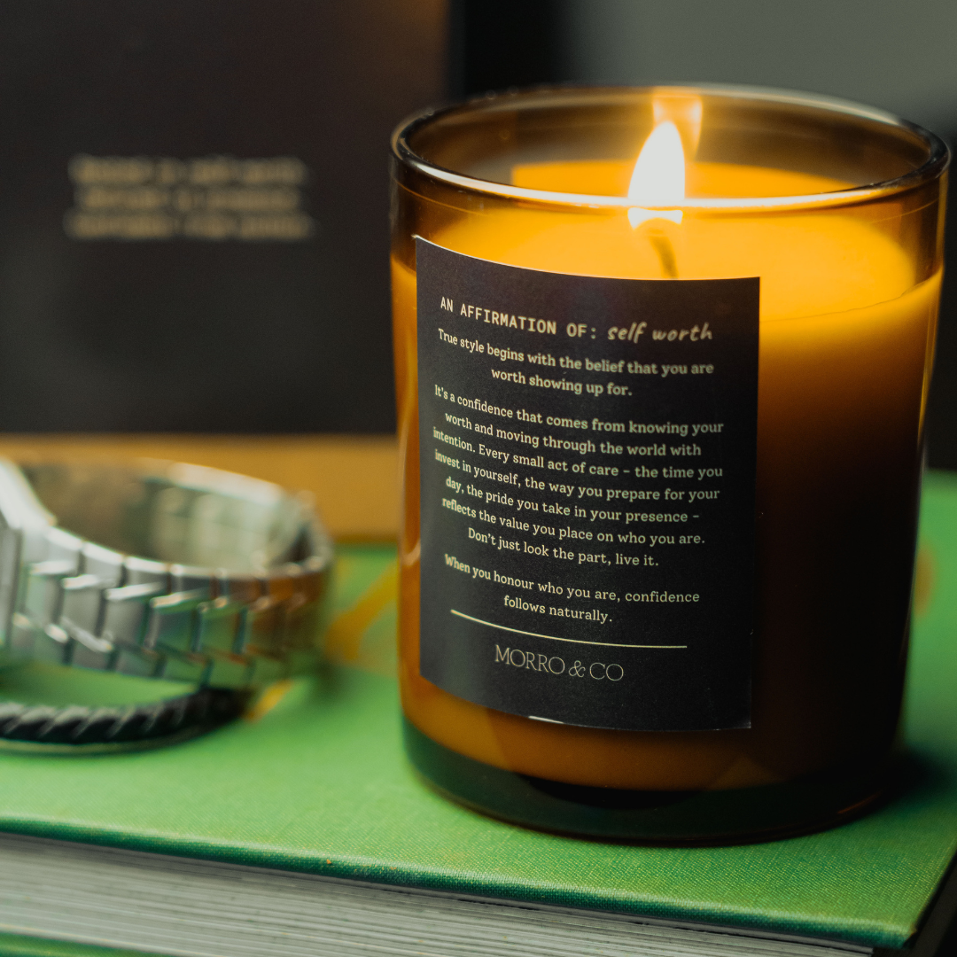 Candle with a label on a green surface, with a blurred background