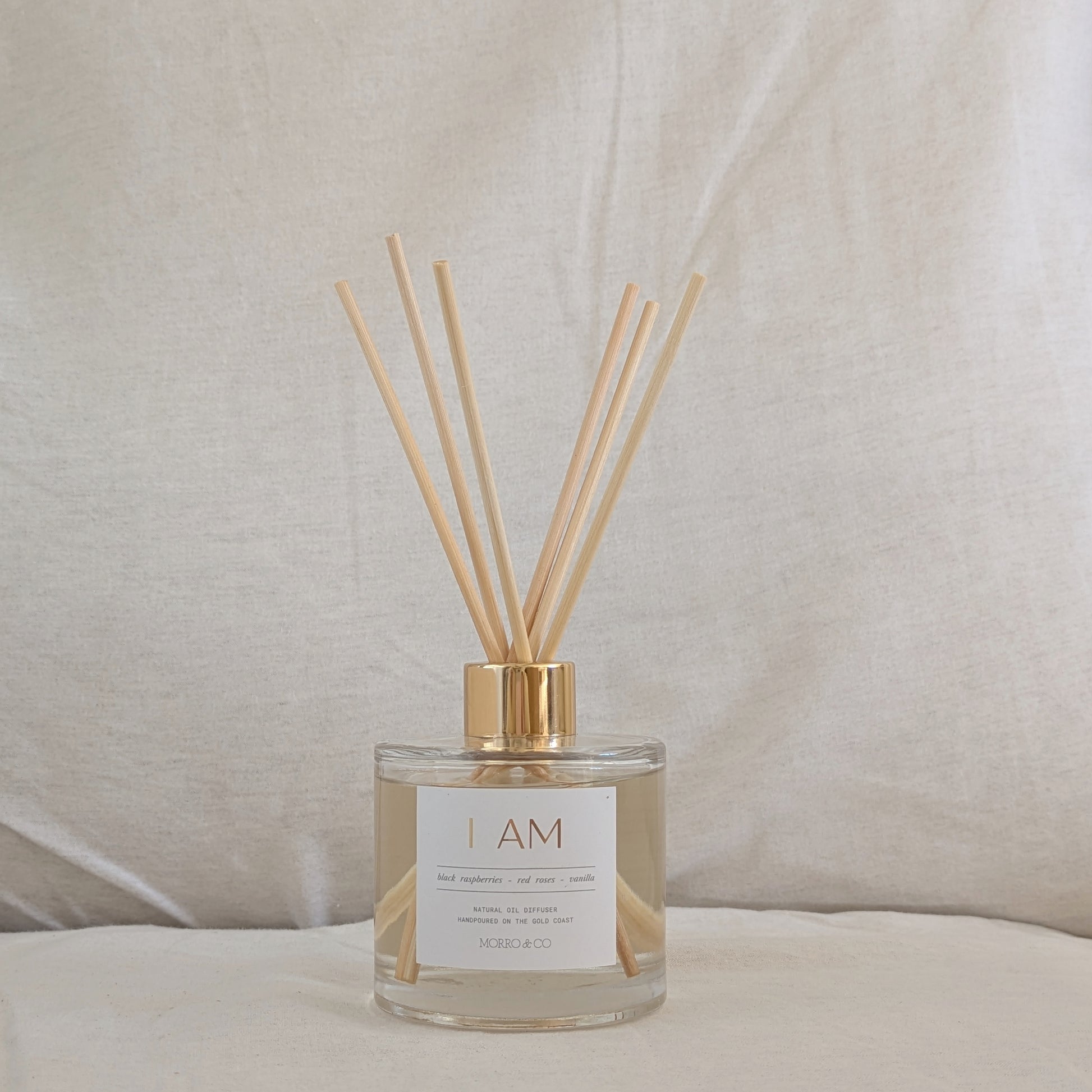 Eco Reed diffuser with wooden sticks in a clear bottle on a neutral background