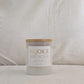 Front of REJOICE candle with 'REJOICE' label on a neutral background