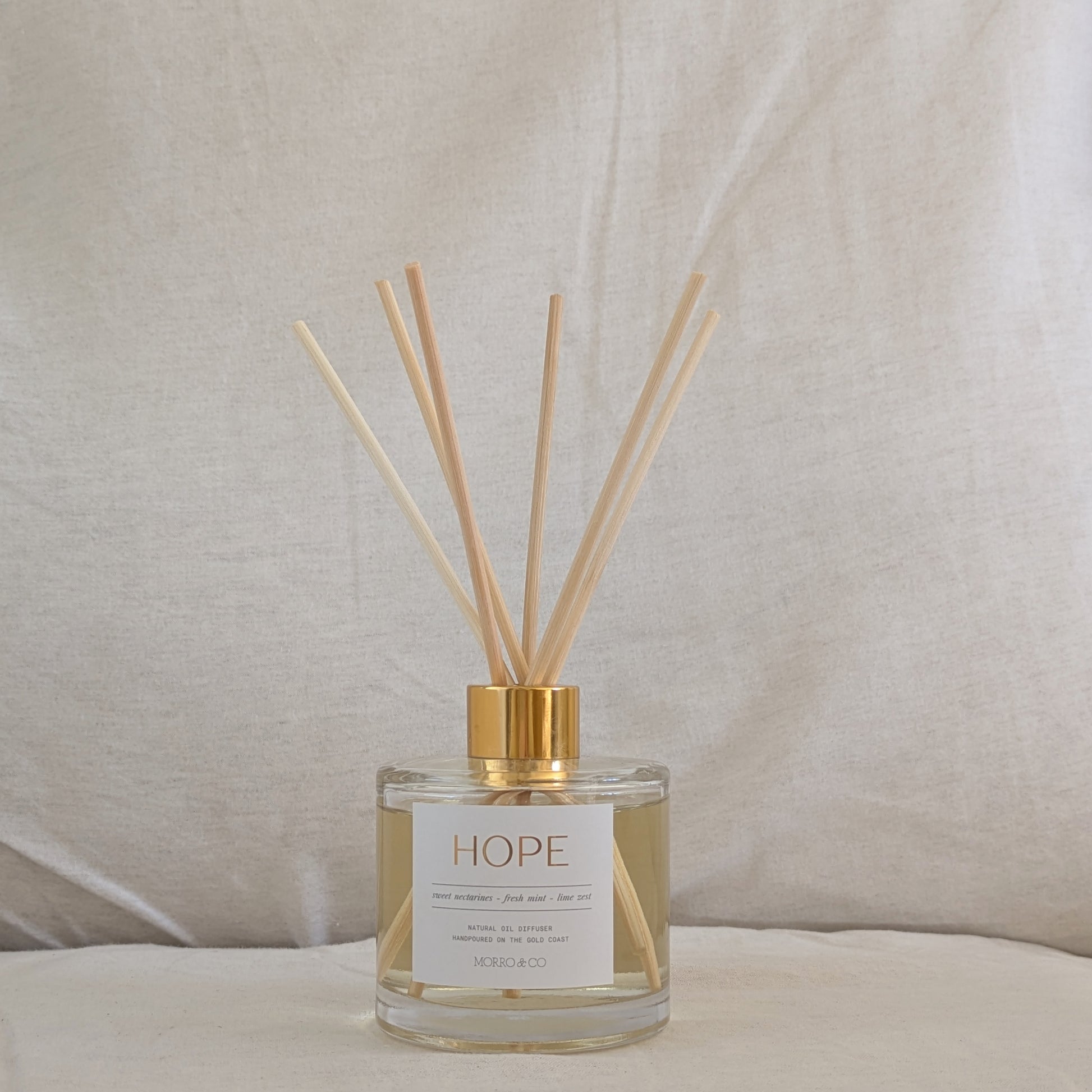 Natural eco reed diffuser labeled 'HOPE' with wooden sticks on a neutral background