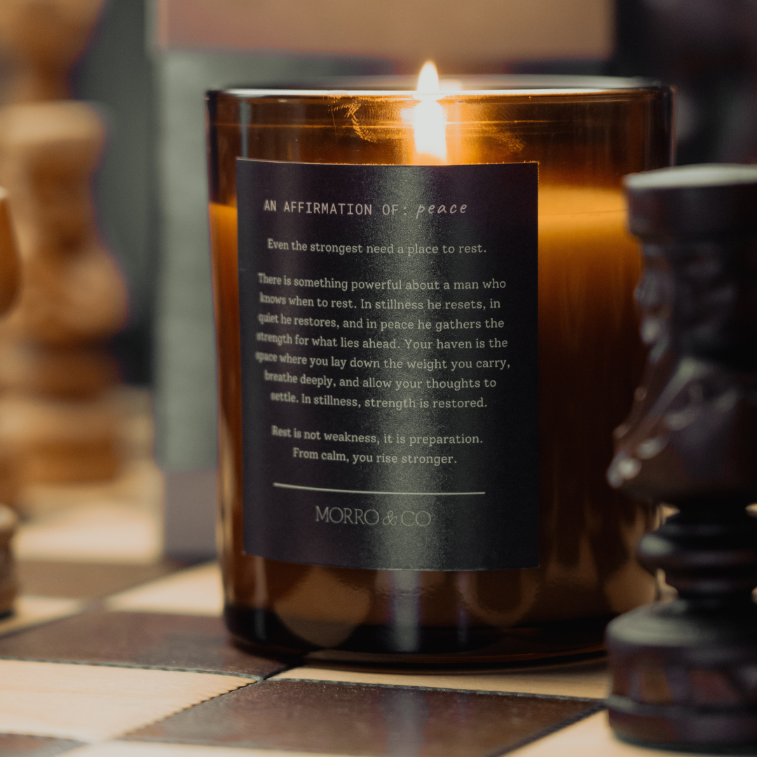 Candle with a label on a checkered surface, surrounded by wooden objects.