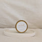 Candle gold travel tin labeled 'HOME' on a beige surface