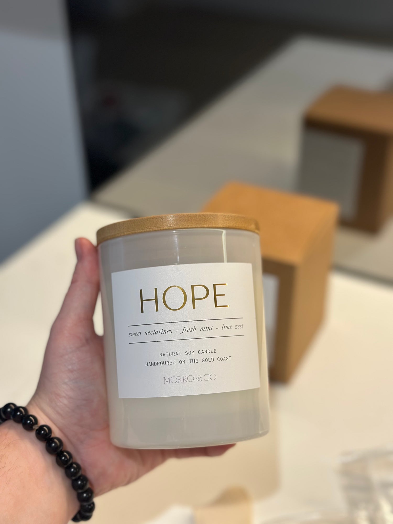 Candle labeled 'Hope' held by a hand with a blurred background