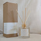Reed diffuser with 'LOVE' label and packaging on a neutral background