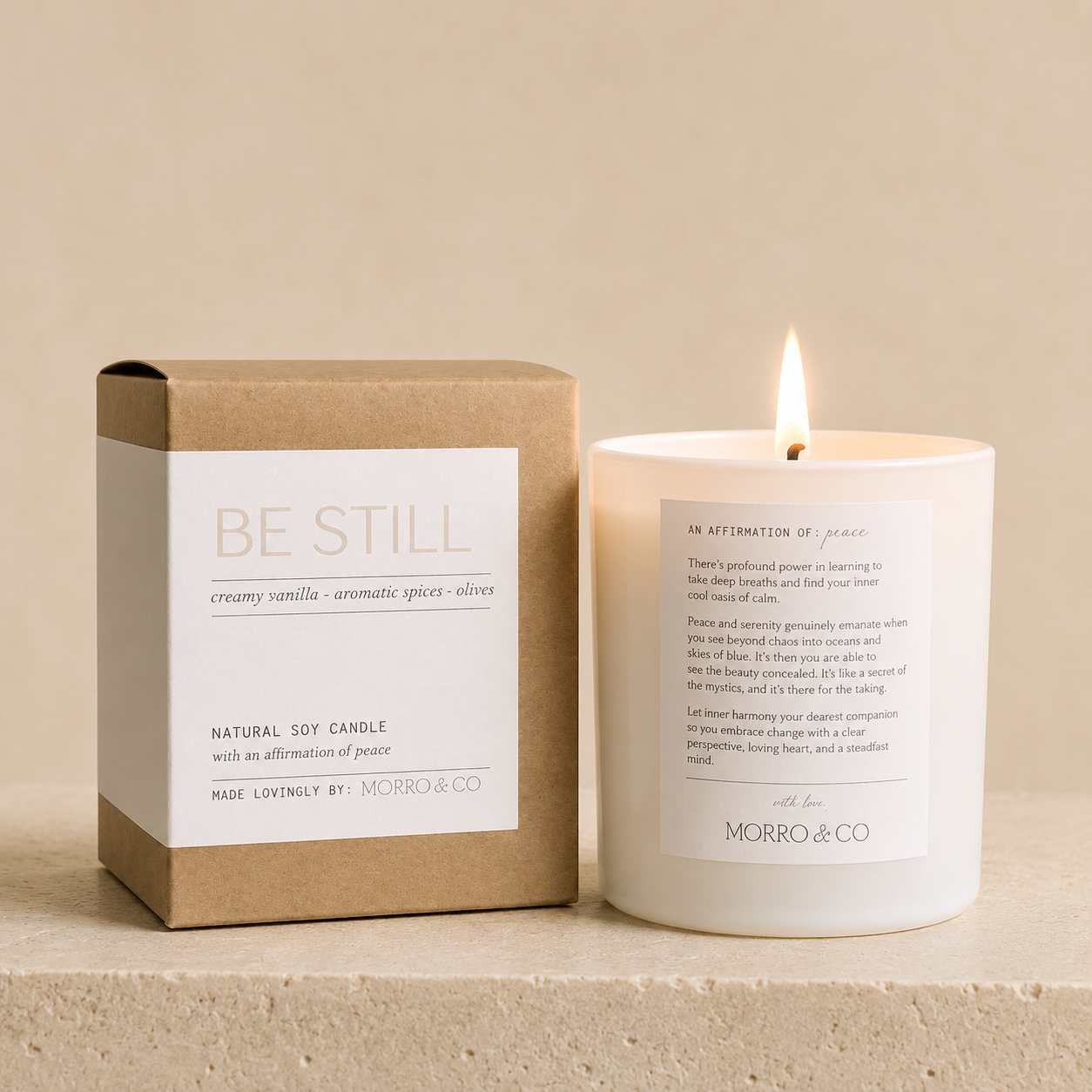 Candle with a box labeled 'Be Still' by Morro & Co on a beige background