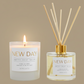 Two 'New Day' products, a candle and a diffuser, on a beige background.