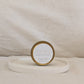 Gold candle travel tin 'Rejoice' on a beige surface