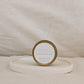 Gold candle travel tin labeled 'STRONG' on a beige surface