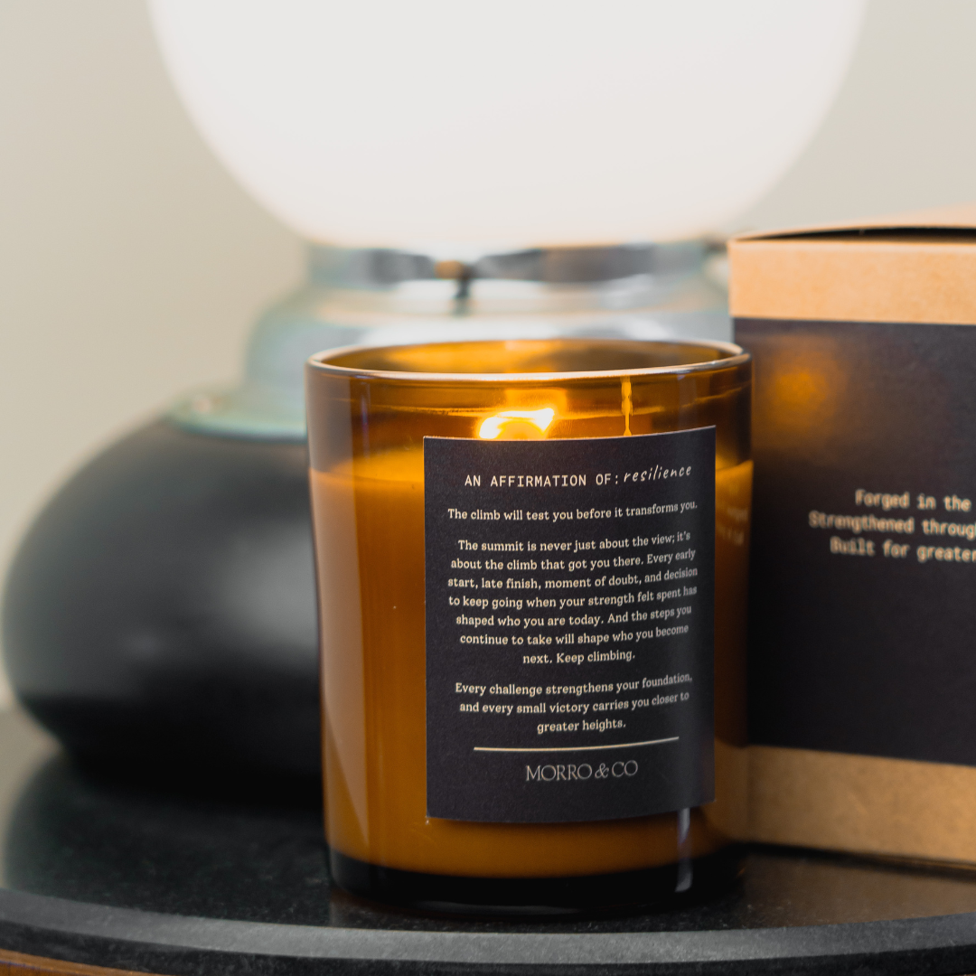 Candle with a label on a surface, with a blurred background