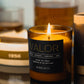 Morro & Co masculine candle labeled 'Valor' on a reflective surface with blurred background