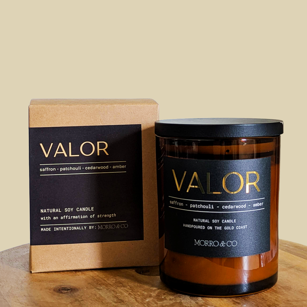 Candle labeled 'Valor' with packaging on a wooden surface