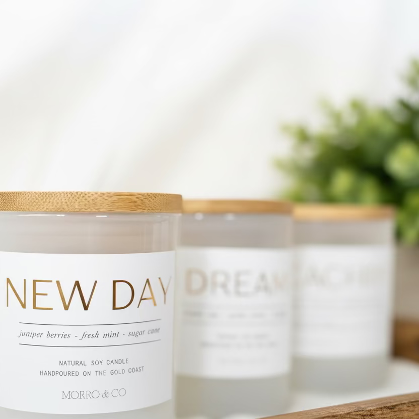 Three candles with labels 'New Day' and 'Dream' on a neutral background