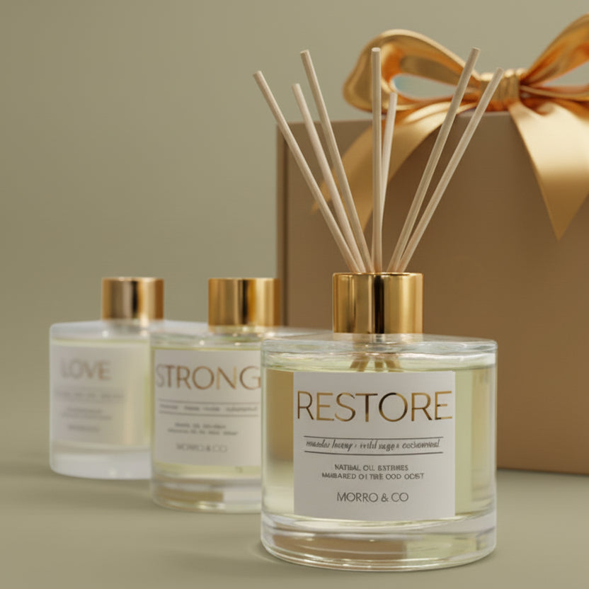 Three bottles of 'Restore' with gold caps on a reflective surface
