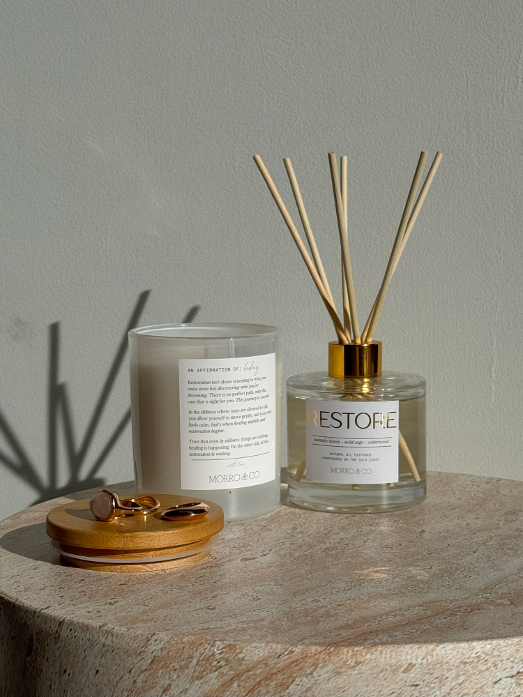 Candle and diffuser with ESTOFIE label on a stone surface
